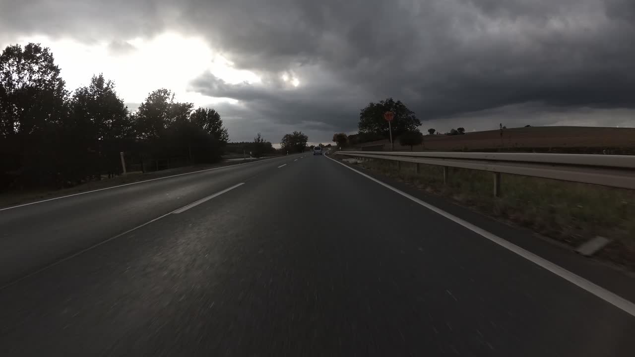 Drive on german highway from the car's point of view with rainy clouds in the background, 4k