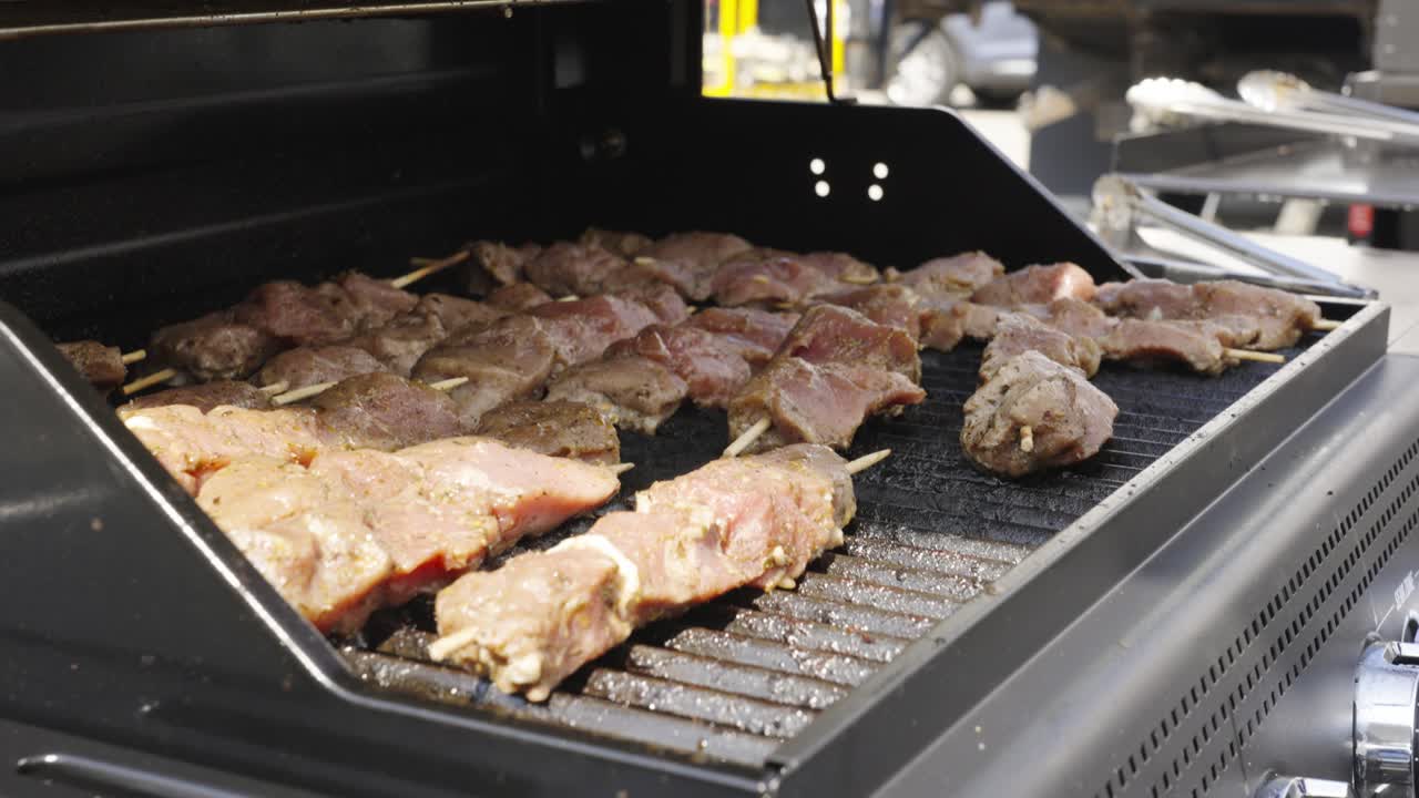 Skewers of meat cooking on a grill