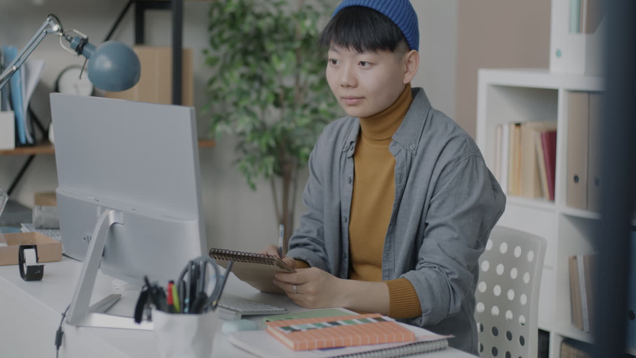 사무실에서 컴퓨터에 앉아 있는 여자