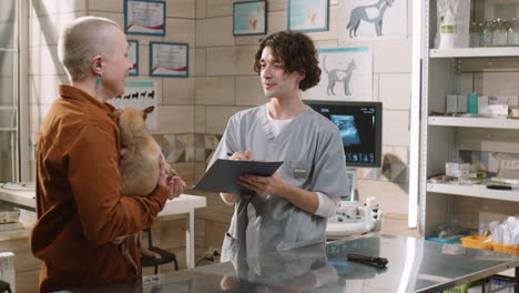 vet examining dog and talking with woman in clinic