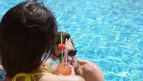 joven pareja adulta coqueteando y hablando en la piscina. fiesta en la piscina de verano. toma en cámara lenta