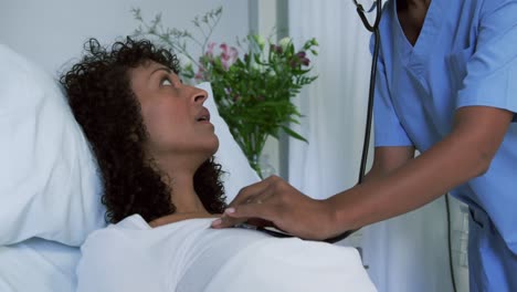 primer plano de una doctora afroamericana examinando a una paciente en la sala del hospital