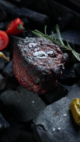 grilled steak with rosemary and salt on charcoal