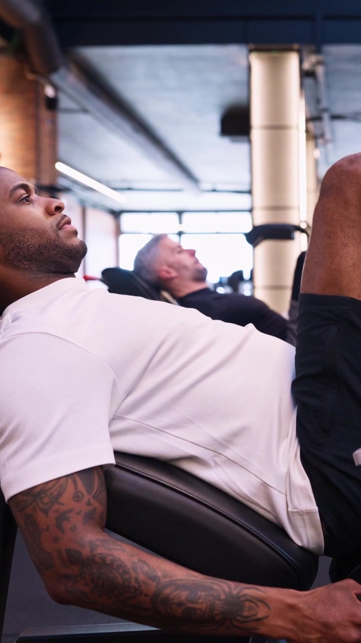 Young Man Performing Leg Press Exercise in Modern Gym