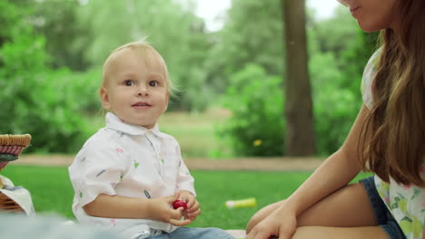 toddler and sister having picnic in park. kids sitting on blanket outdoors