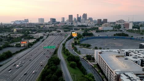 Horizonte-De-Atlanta,-Georgia-Al-Atardecer-Con-Tráfico-De-Autopista-Y-Establo-De-Video-De-Drones