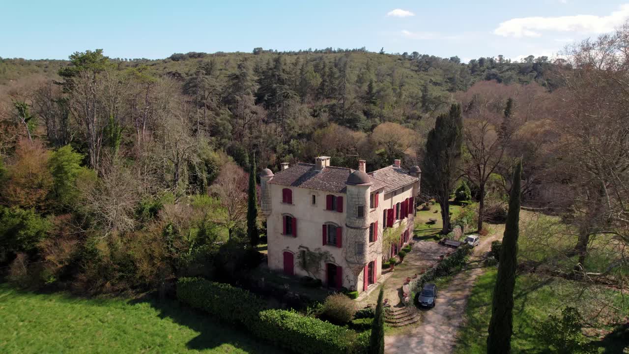 건물의 모이에 타워가 있는 작은 오래된 집의 드론으로 공중 전망, 나무, 풀 및 관목으로 둘러싸인 자연