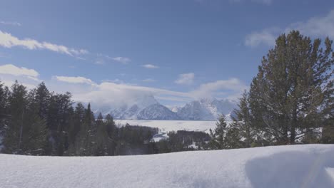 Low-Angle-Handheld-Shot-Der-Teton-Range-Im-Westen-Von-Wyoming-Mit-Schnee-Im-Vordergrund