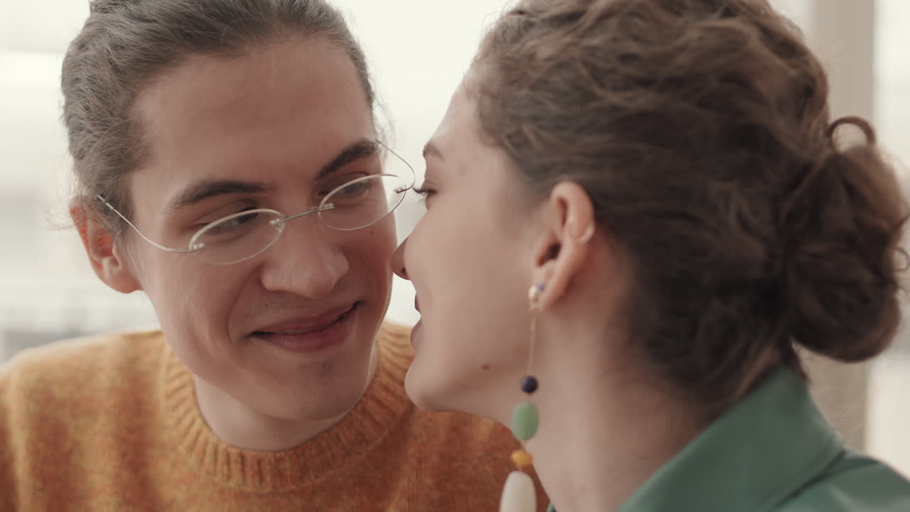 una mujer besando a un hombre en la mejilla.