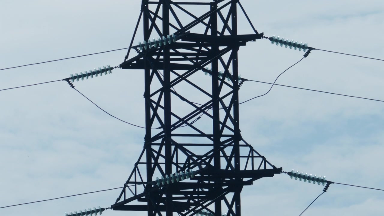 Close up view of a high voltage electricity transmission tower and power lines