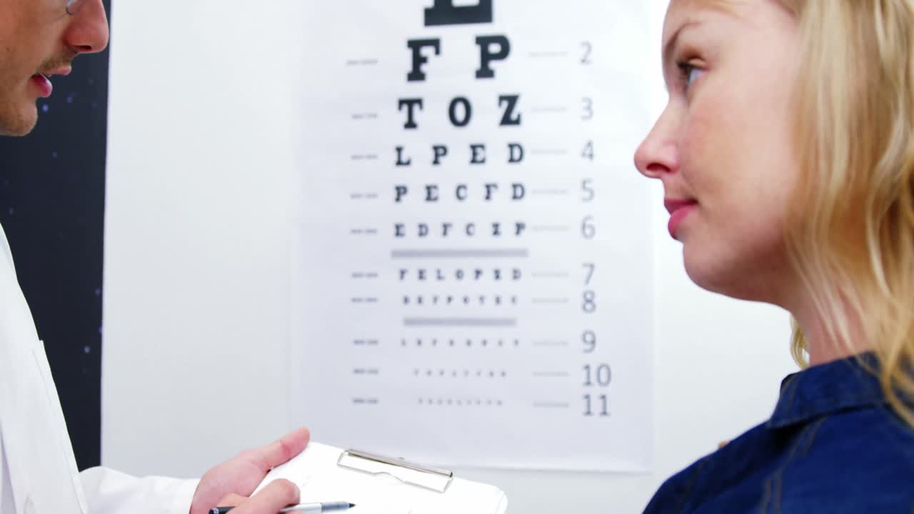 안과 의사가 여성 환자의 눈 검사 보고서에 대해 논의합니다.