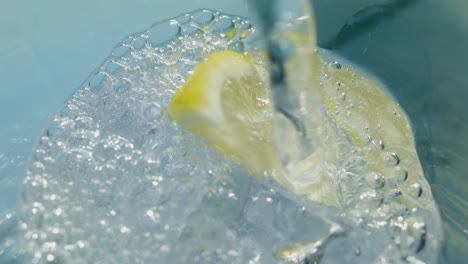 refreshing beverage poured over ice and lemon slice