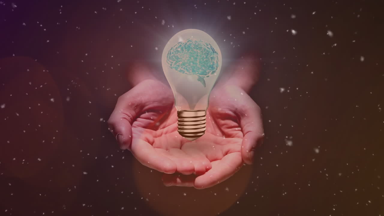 partículas blancas que caen sobre la bombilla eléctrica sobre las manos cubiertas contra manchas de luz en el fondo