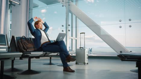 airport terminal: businessman uses laptop computer, waiting for flight. traveling man relax after work, looking forward to vacation. sitting in a boarding lounge of airline hub with airplanes
