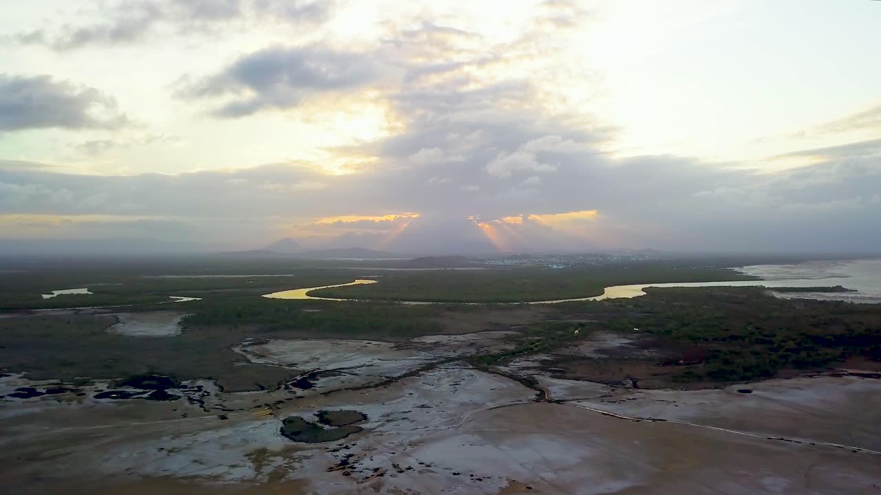 멀리서 일몰과 함께 느린 호를 그리며 이동하는 넓은 열린 공간 위의 대략 높은 높이에서 비행하는 드론