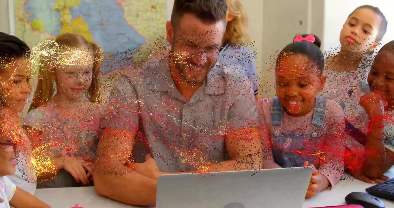 Smiling teacher wearing grey shirt guiding children at class table, with laptop, sparkle effect