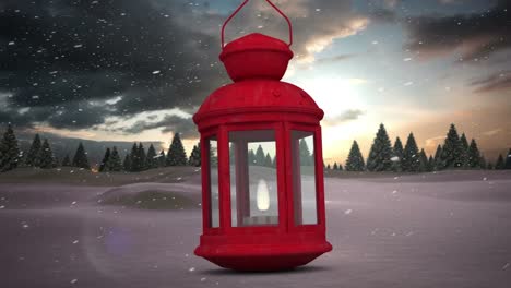 lámpara de navidad roja contra la nieve cayendo sobre varios árboles en el paisaje de invierno