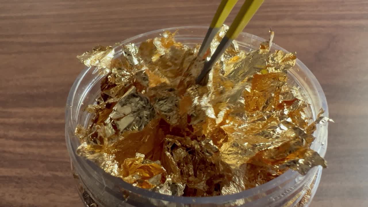 유리 비 에서 섬세 한 금 잎 을 뽑는 핀세이저 의 클로즈업