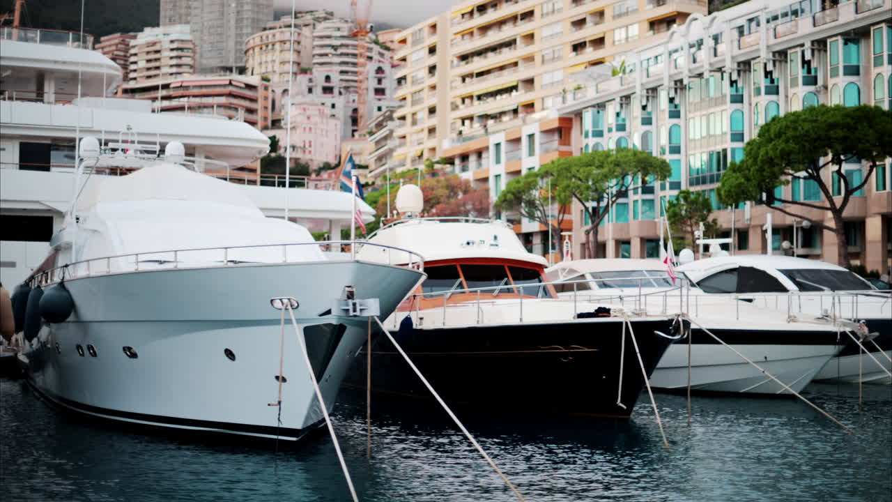 View of boats docked in the Monaco Marina with the skyline of the city on the background