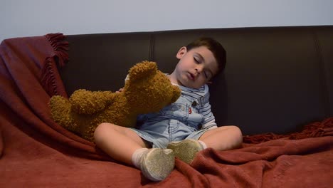 lindo niño cansado que se queda dormido en el sofá - expresiones divertidas de la cara del bebé