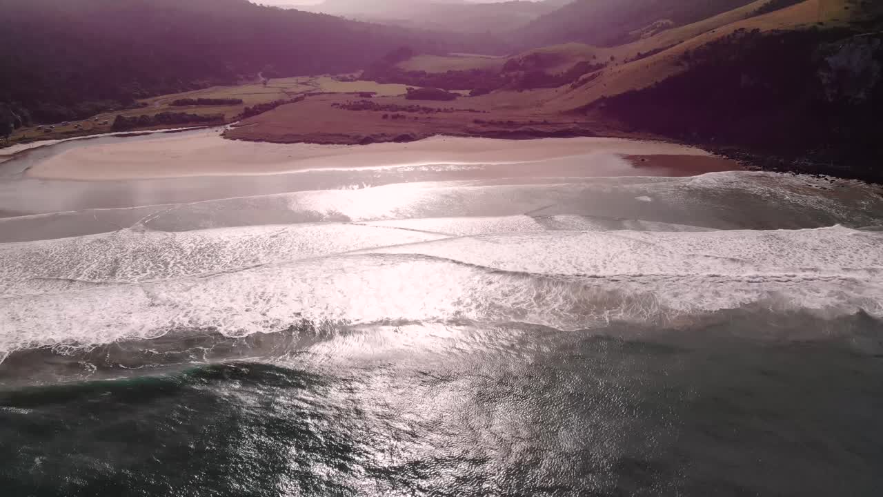 puranakui bay, en nueva zelanda revelan la bonita playa y un lugar de surf volar hacia atrás, durante el día de verano