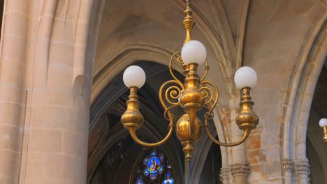 una foto de cerca de una lámpara de araña dentro de la iglesia católica romana de saint-germain-l'auxerrois en parís, francia