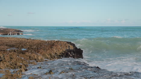 slow motion shot of waves crashing into the rocks towards the camera at caribbean sea