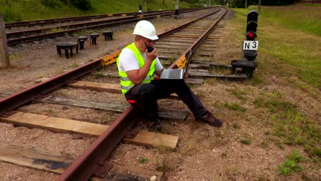 railway engineer with laptop on walkie talkie