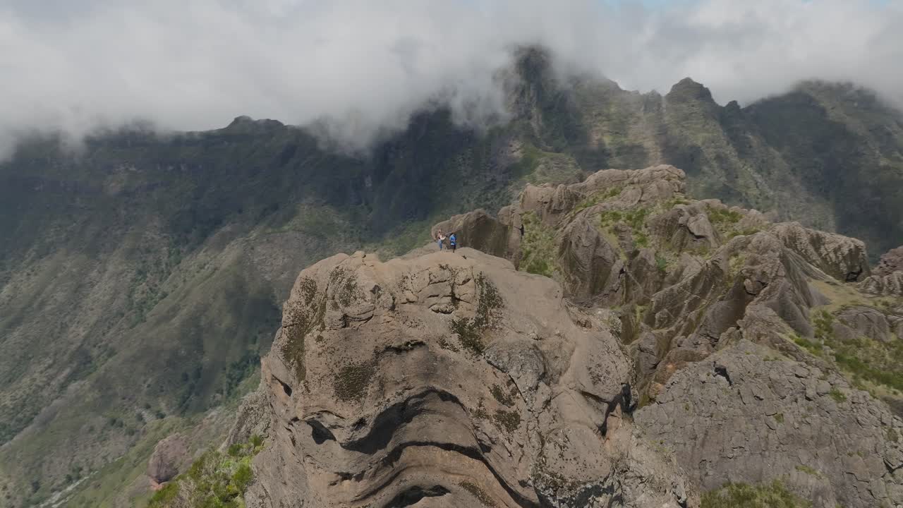 excursionistas locos en el pináculo de la roca grande en la cordillera escénica en un día soleado