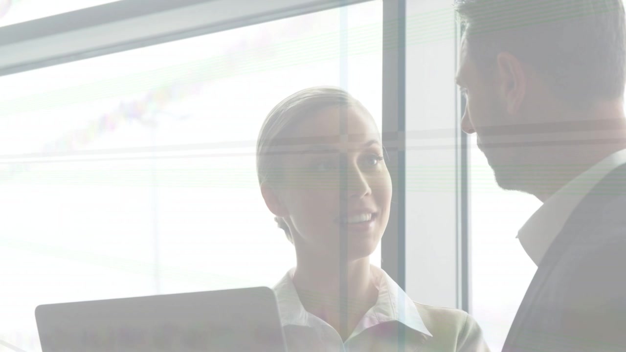 Woman presenter tilting laptop and speaking by window, drawing colleague closer for business review