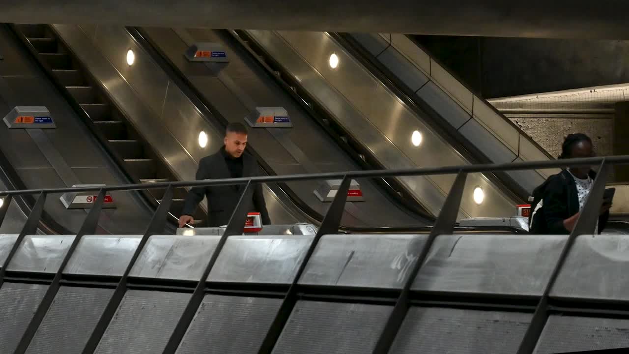 People Riding Escalators in a London Underground Station
