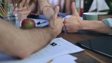 close up of business people hands showing thumbs up. team work concept