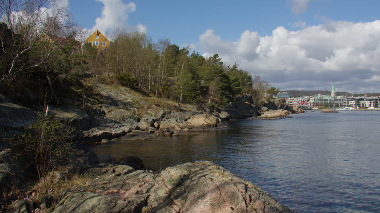 Wide shot looking over Kristiansand Rocky shoreline to its harbour from Odderøya