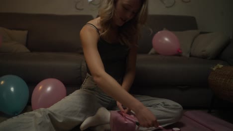 una adolescente abriendo un regalo de cumpleaños