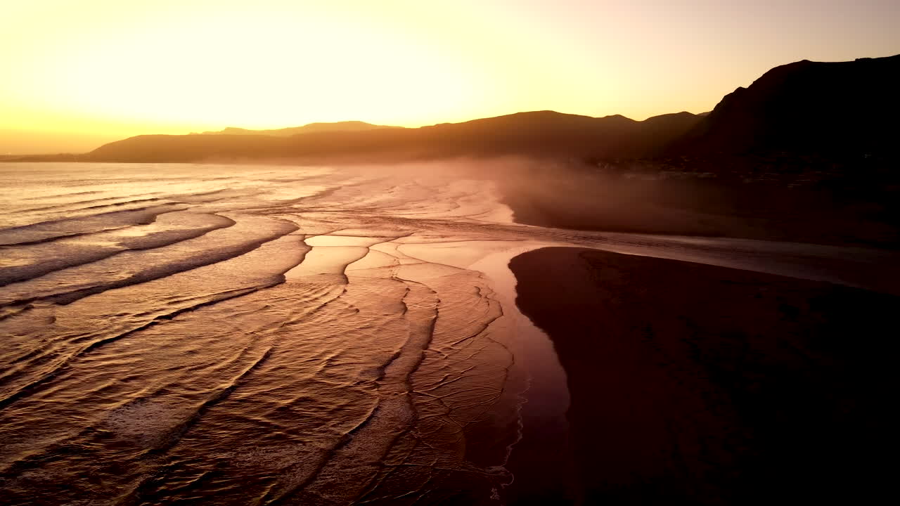 vista aérea de la hora dorada sobre la playa de la gruta con la ruptura de la desembocadura del río klein