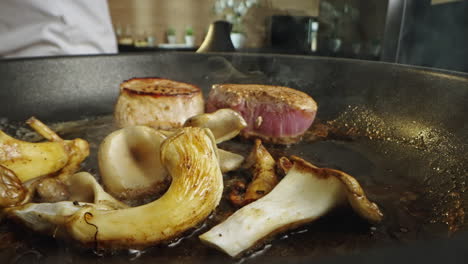 meat and mushrooms being cooked in a pan