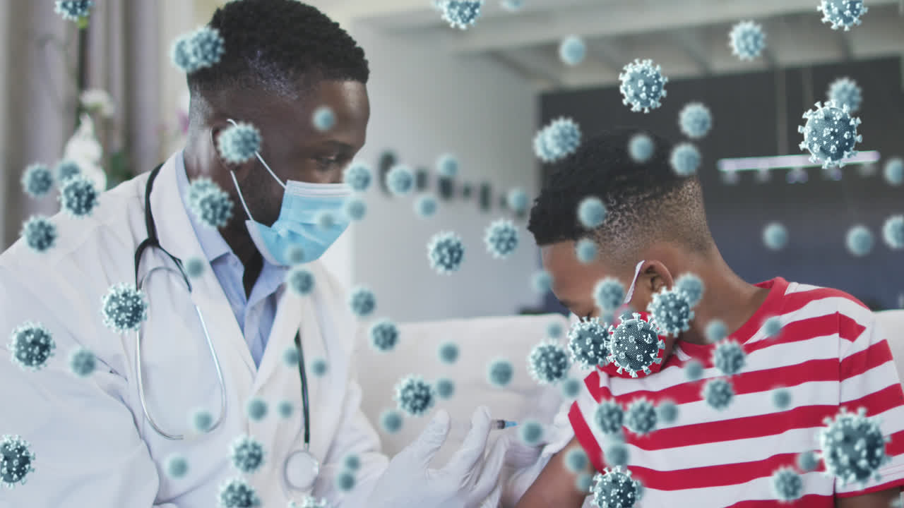 Animation of covid 19 cells over african american boy in face mask receiving vaccination