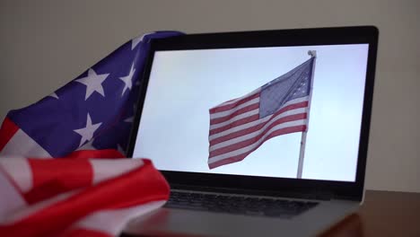 abrir la computadora portátil y la bandera de los ee.uu. en la pantalla componer.