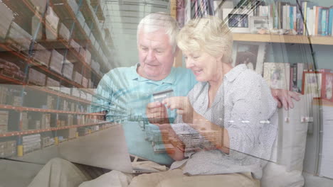 pareja de ancianos caucásicos en distanciamiento social comprando en línea en casa