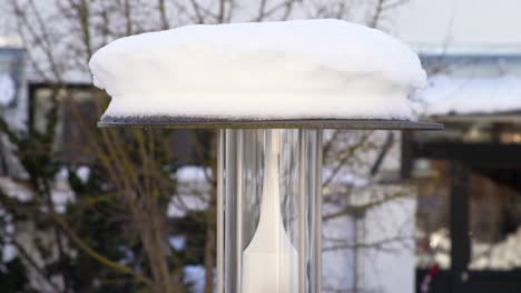 Timelapse-of-falling-waterdrops-down-from-a-lantern,-while-the-snow-melts