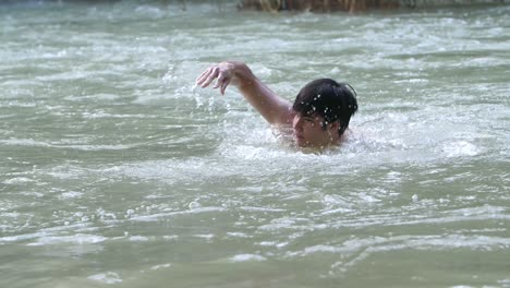 asian man swim in nature swimming pool, slow motion