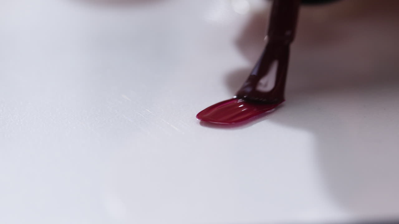 어두운 빨간색 손 라크를 적용합니다.