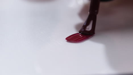 aplicación de esmalte de uñas rojo oscuro