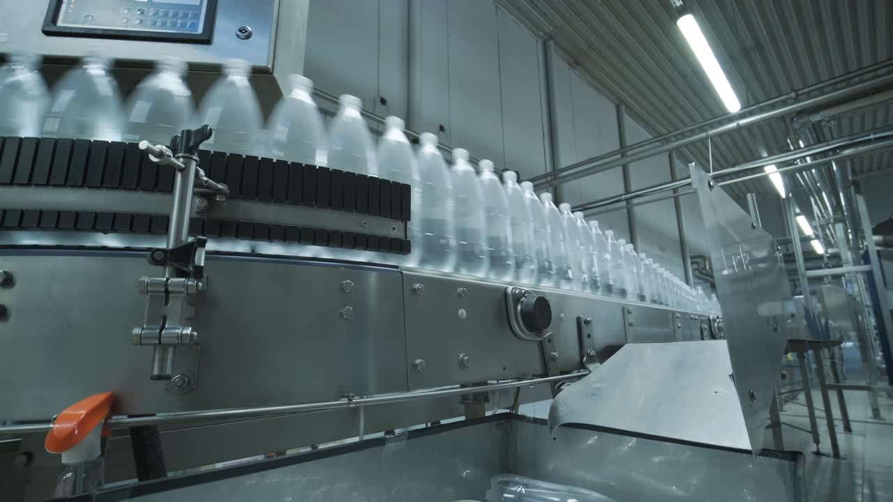 Conveyor belt with bottles of drinking water at a modern beverage plant