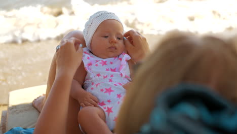 mom and baby on sunbed near the sea