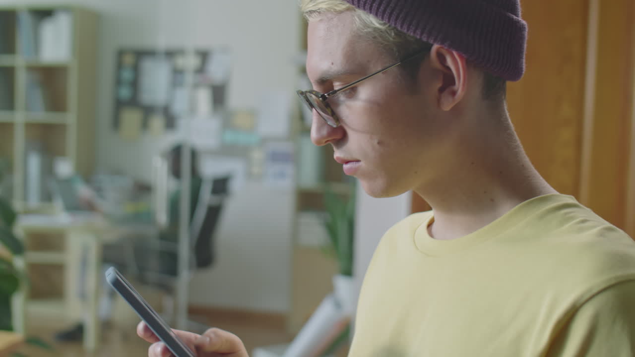 Gen Z Man Surfing The Internet on Smartphone in Office