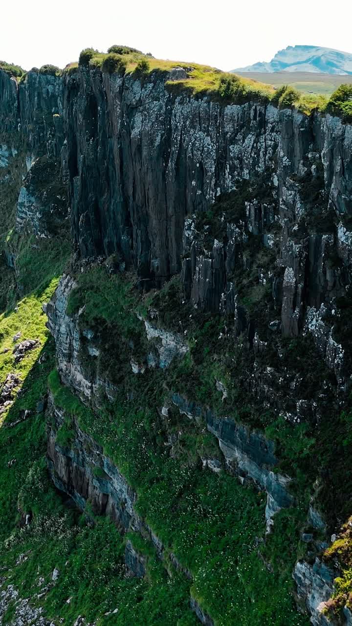 Dramatic cliffs rise above the shimmering waters of Scotland's coastline