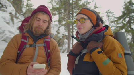 couple using navigation app on phone during winter hike