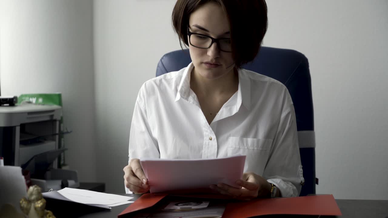 mujer leyendo documentos en la oficina