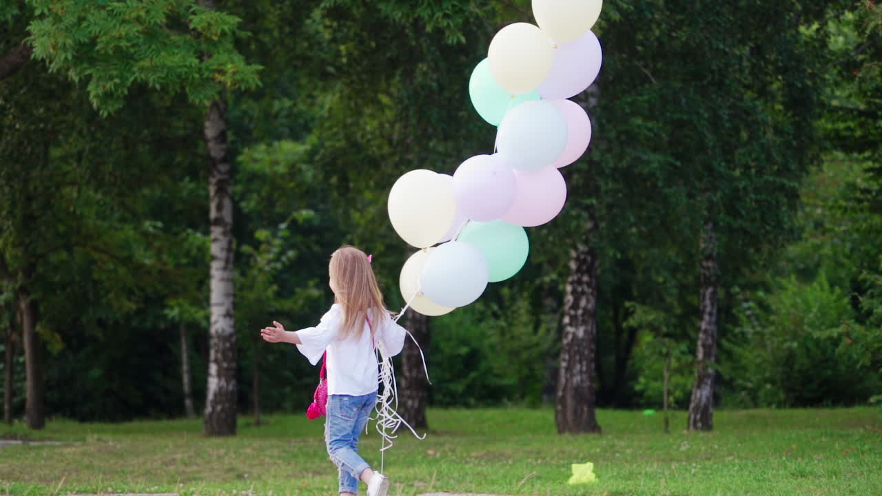 Little girl running in park. Happy little girl running outdoors with balloons in park